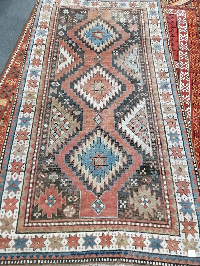 A Caucasian red ground rug, 230 x 128cm